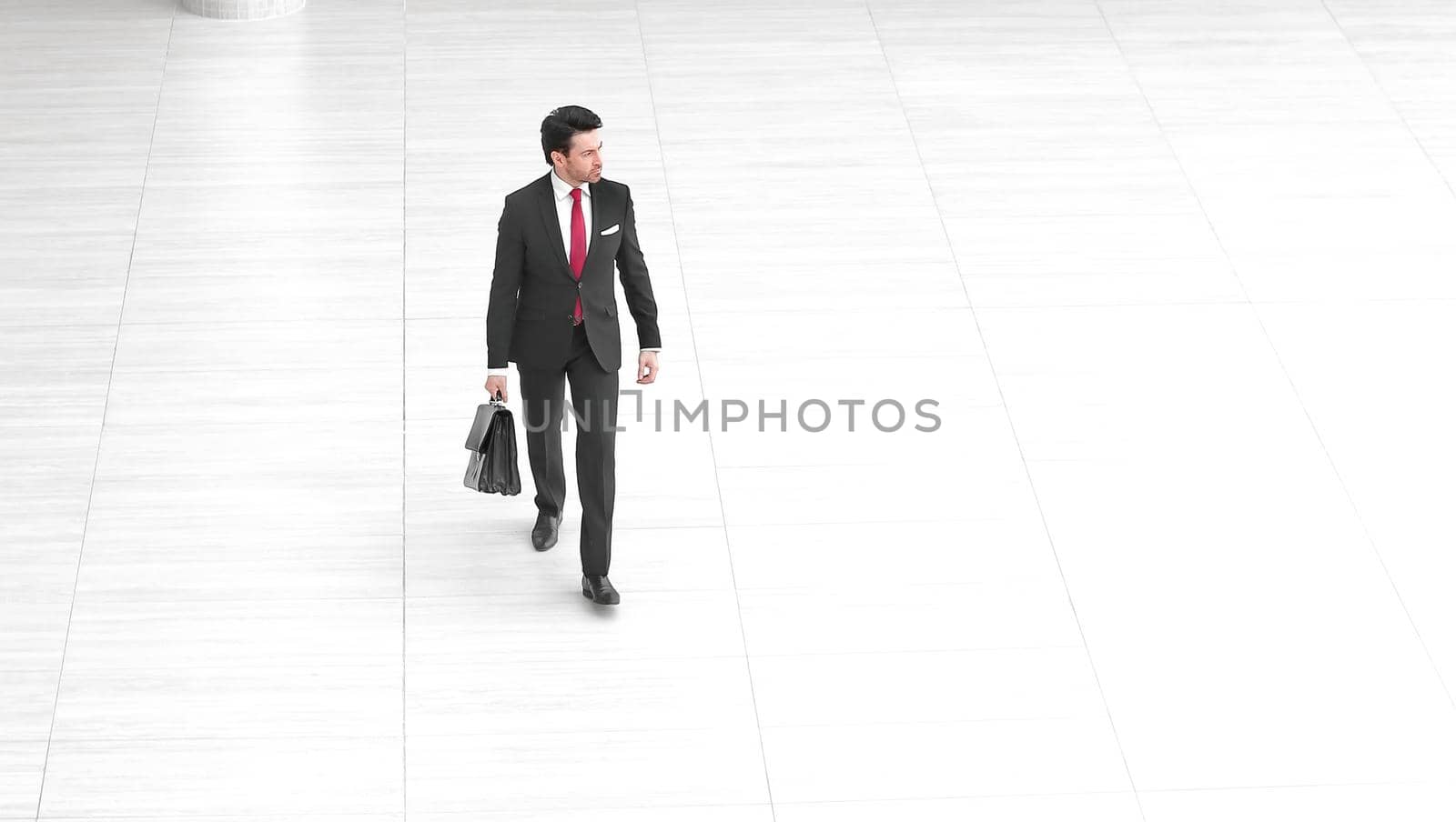 rear view from afar.a businessman with a leather briefcase walks . photo with copy space