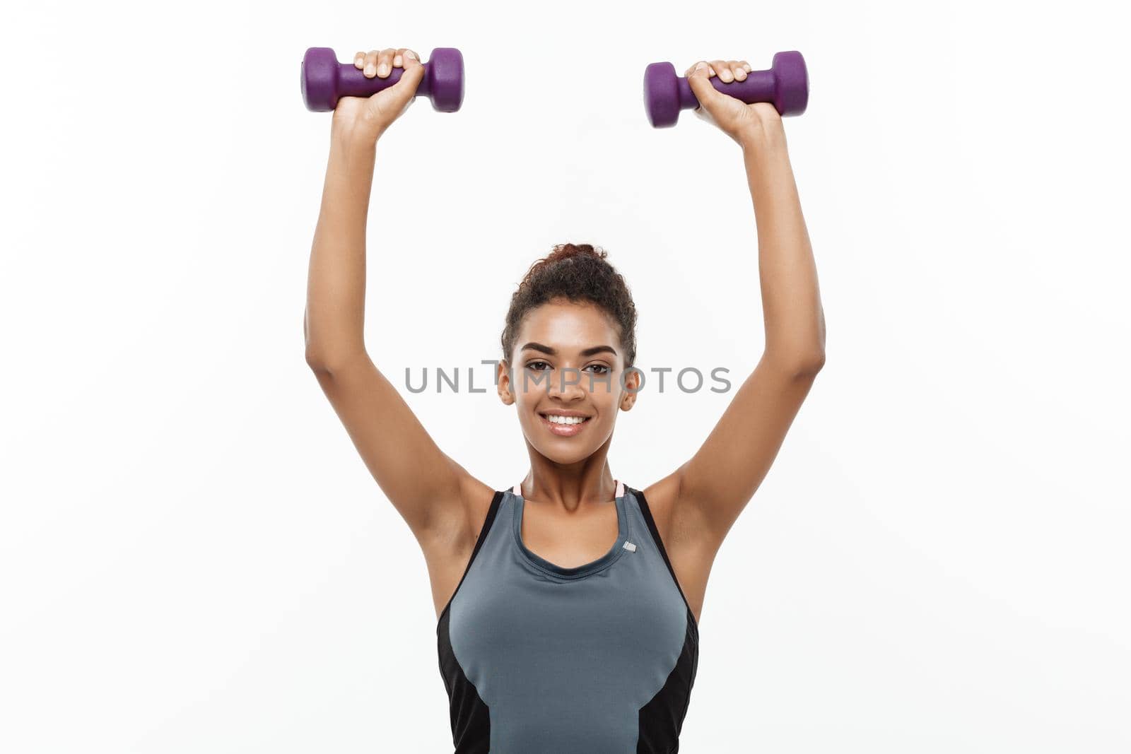 Healthy and Fitness concept - Beautiful American African lady in fitness clothes workout with dumbbell. Isolated on white background