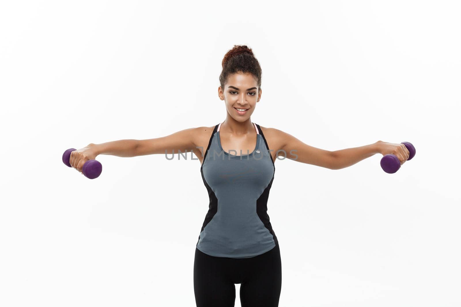 Healthy and Fitness concept - Beautiful American African lady in fitness clothes workout with dumbbell. Isolated on white background