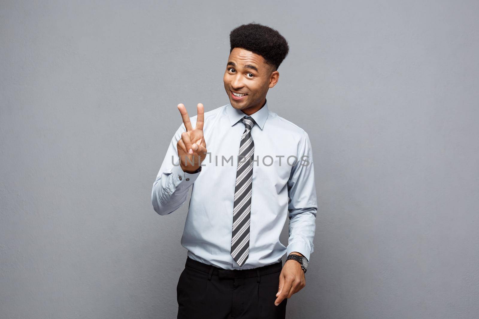 Business Concept - portrait of African American holding two peace or two fingers sign