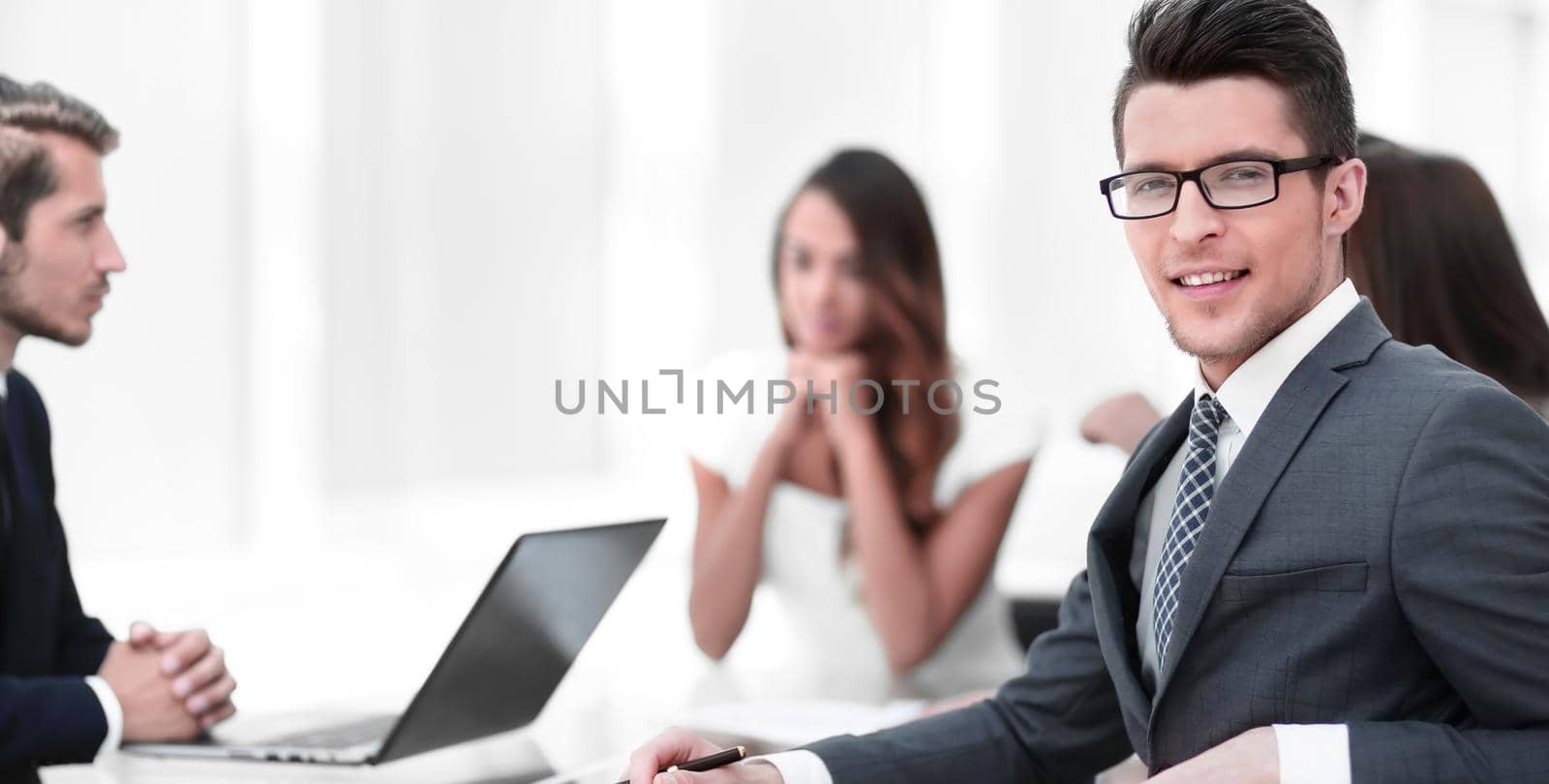 young businessman with his business team sitting at his Desk.business concept