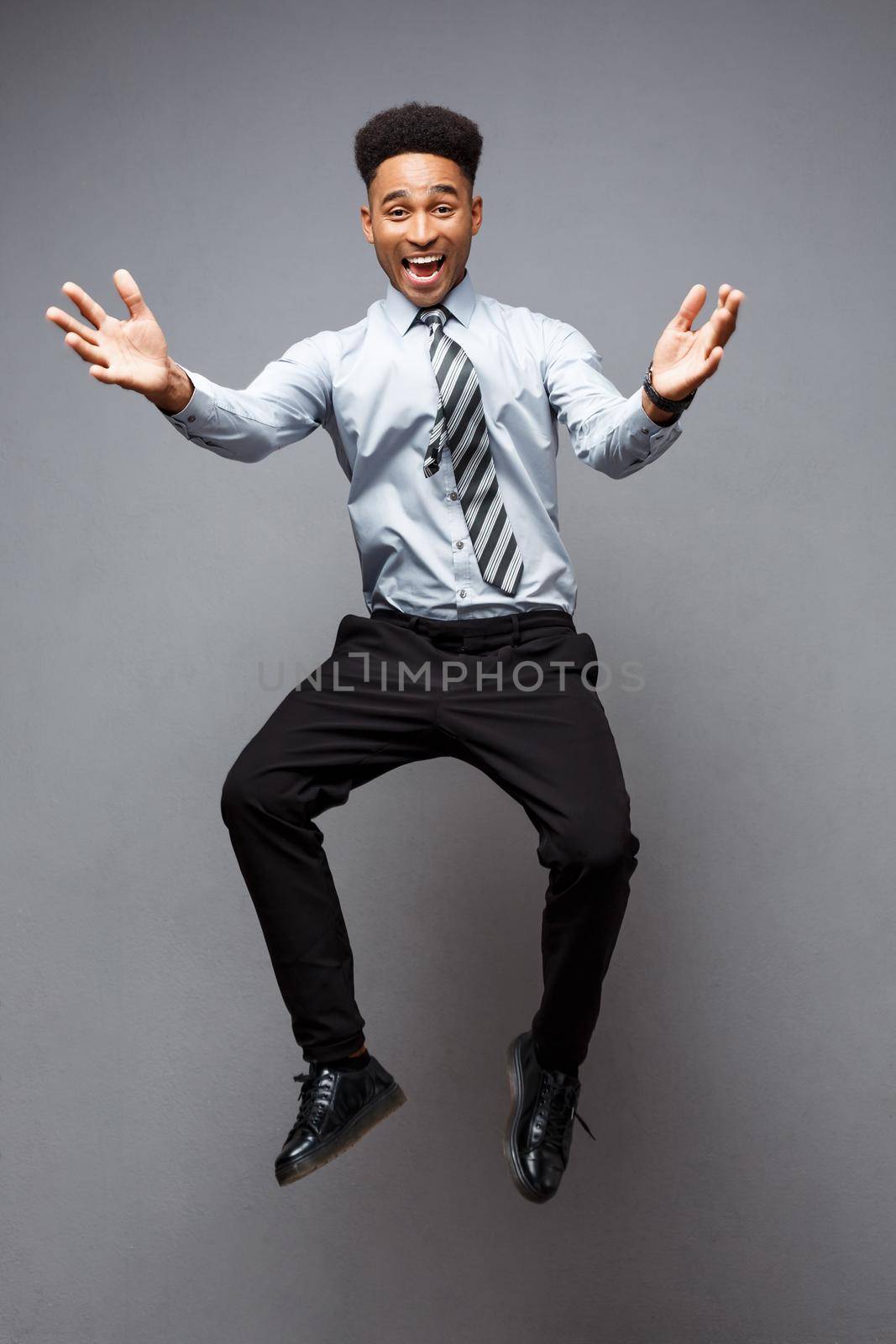 Business Concept - Full length portrait of successful african american businessman happy jumping in the office. by Benzoix