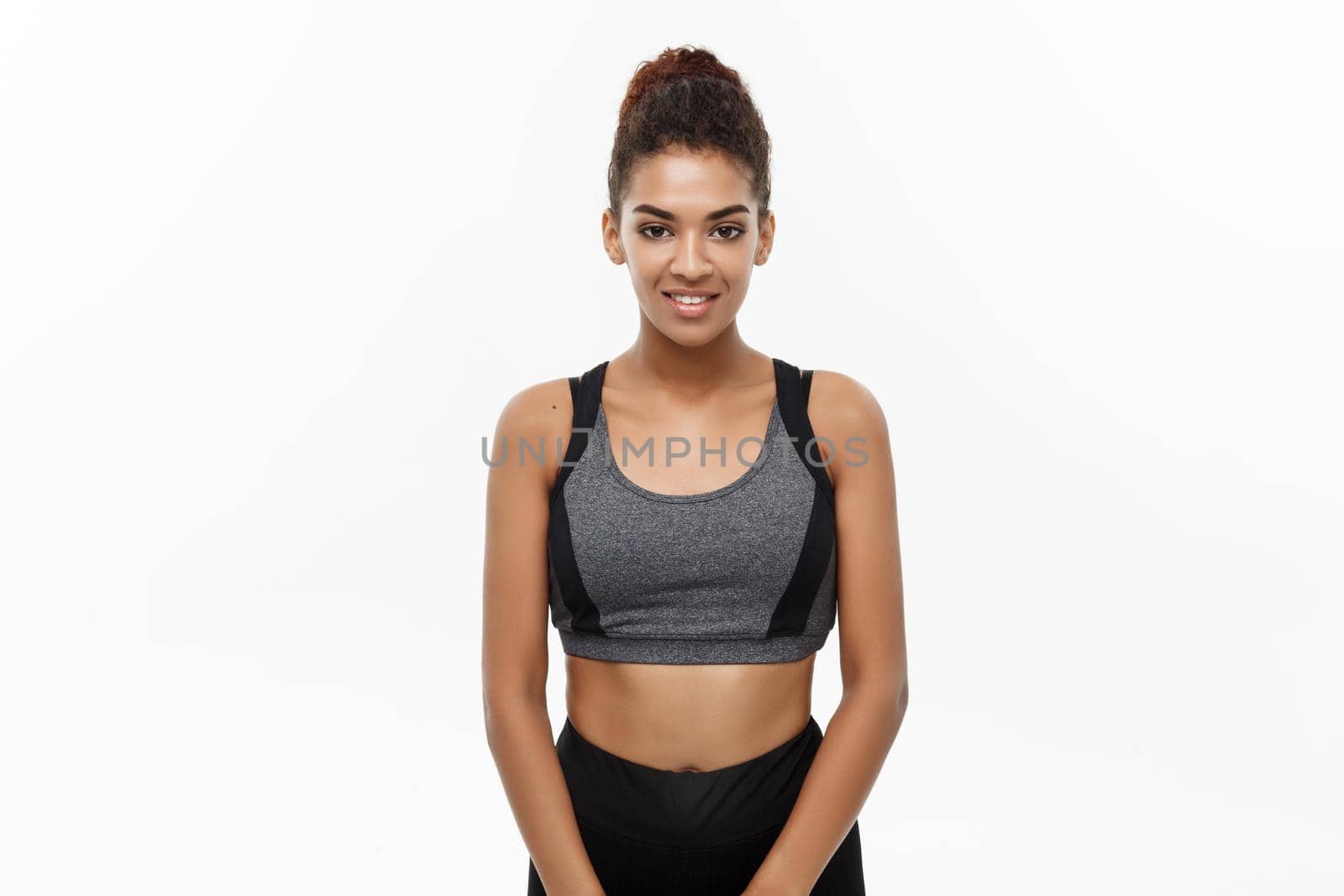 Healthy and Fitness concept - Beautiful American African lady in fitness clothes ready for workout. Isolated on white background