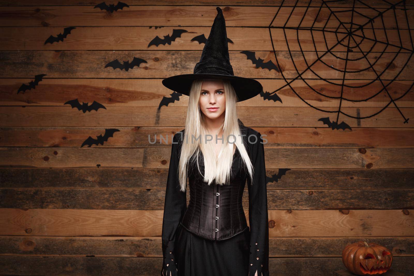 Halloween witch concept - Happy Halloween Sexy Witch holding posing over old wooden studio background