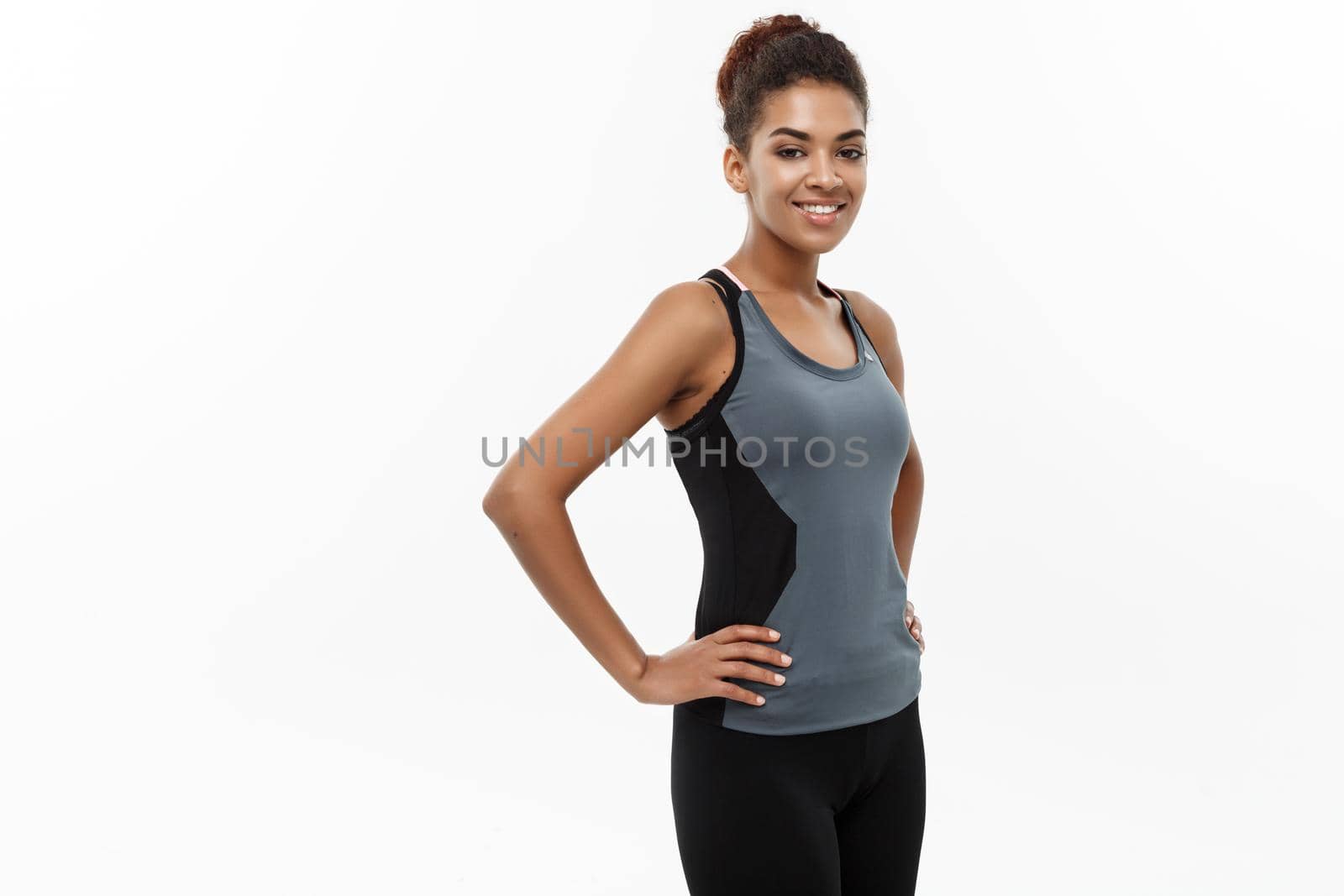 Healthy and Fitness concept - Beautiful American African lady in fitness clothes ready for workout. Isolated on white background