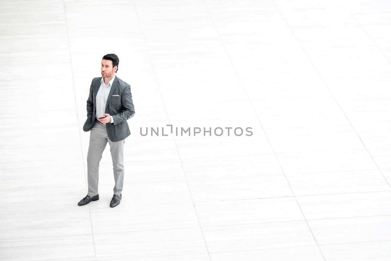 view from afar.businessman looks at the screen of the smartphone.photo with copy space