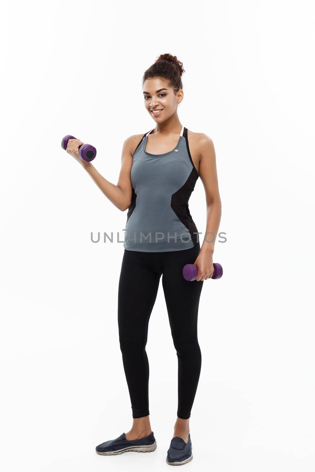 Healthy and Fitness concept - Full-length of portrait Beautiful American African lady in grey fitness clothes workout with dumbbell. Isolated on white background