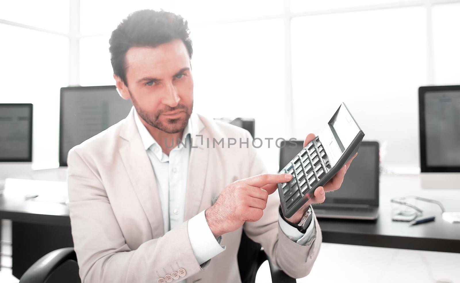 stylized photo.Businessman pointing to the calculator.photo with copy space