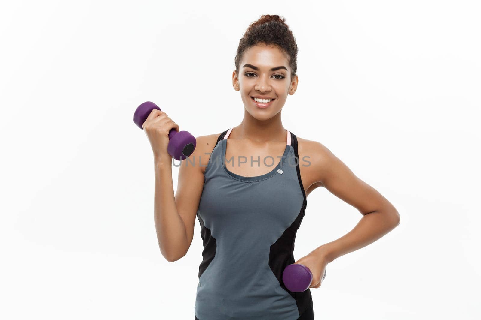 Healthy and Fitness concept - Beautiful American African lady in fitness clothes workout with dumbbell. Isolated on white background. by Benzoix