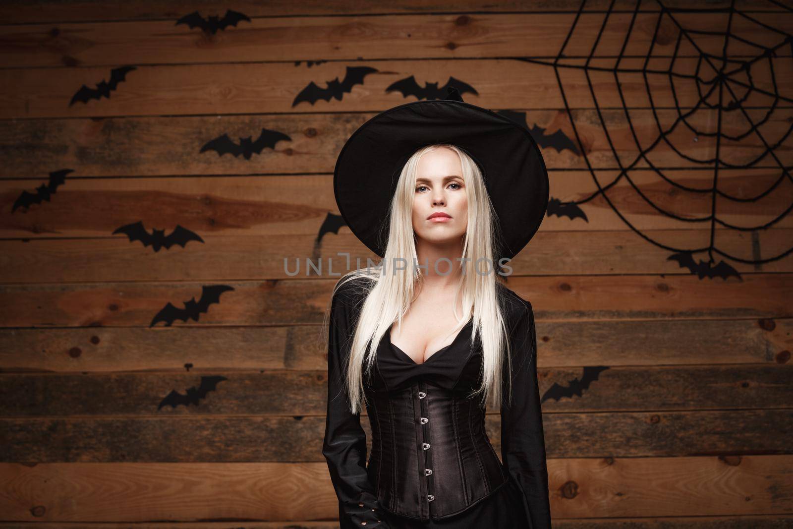 Halloween witch concept - Happy Halloween Sexy Witch holding posing over old wooden studio background. by Benzoix