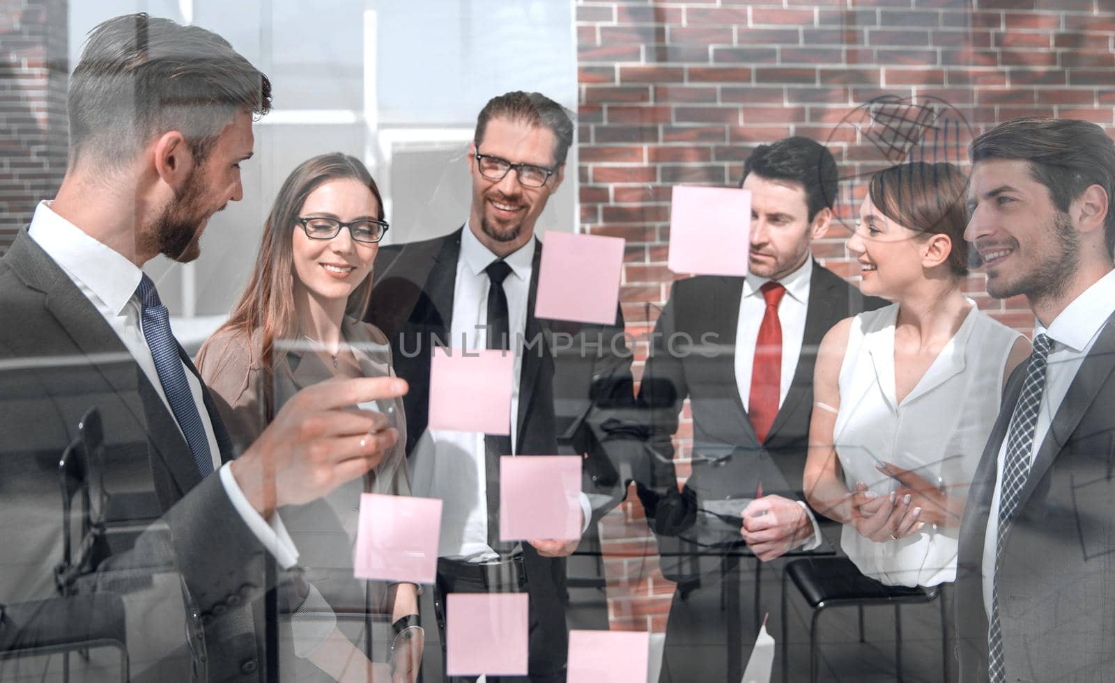 group of business people looking at notes on glass by asdf