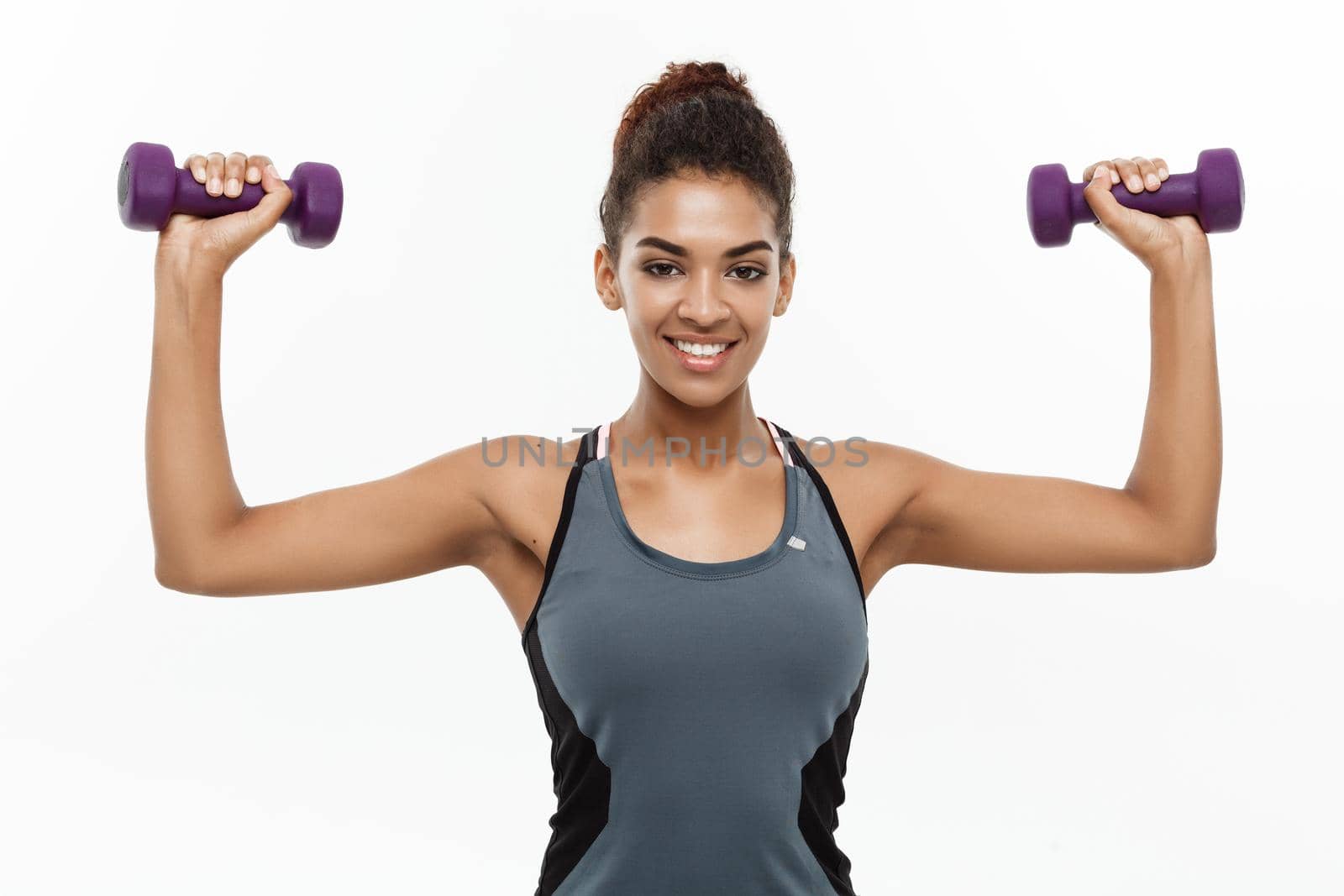 Healthy and Fitness concept - Beautiful American African lady in fitness clothes workout with dumbbell. Isolated on white background. by Benzoix