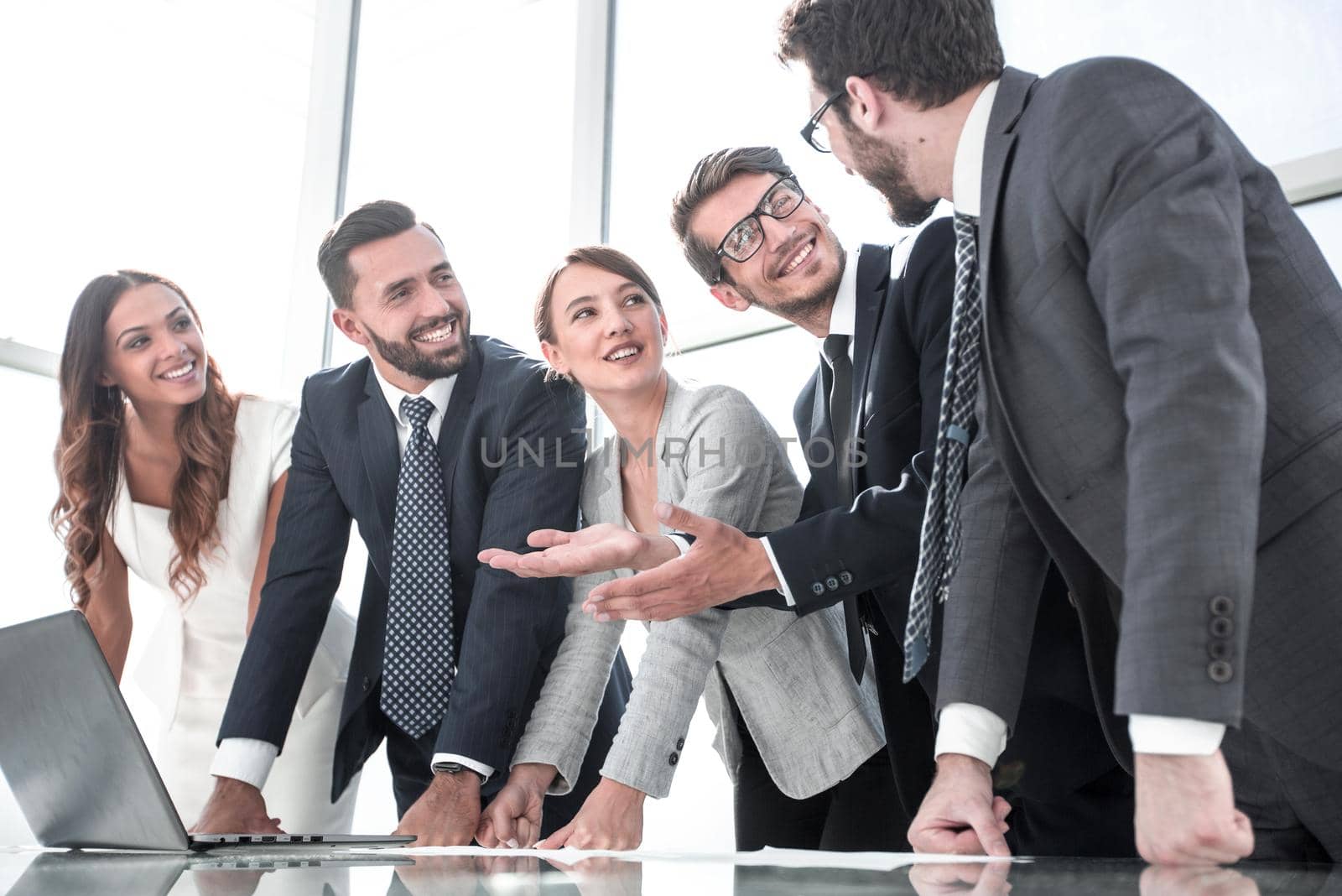 business team discussing something while standing near the desktop by asdf