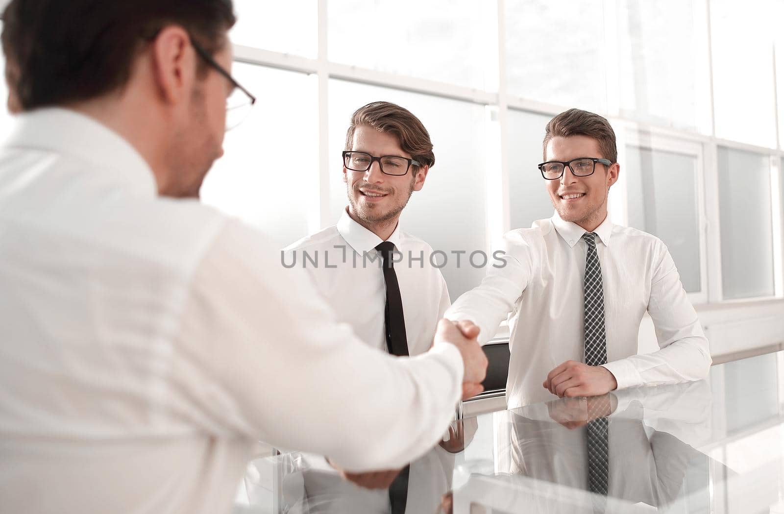 handshake business people at the Desk in a spacious office.
