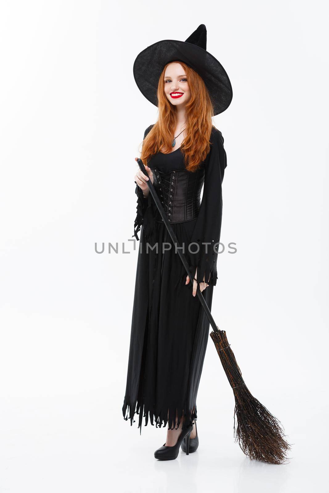 Halloween Witch Concept - Full-length Happy elegant witch with broomstick for celebrating halloween party over white background. by Benzoix