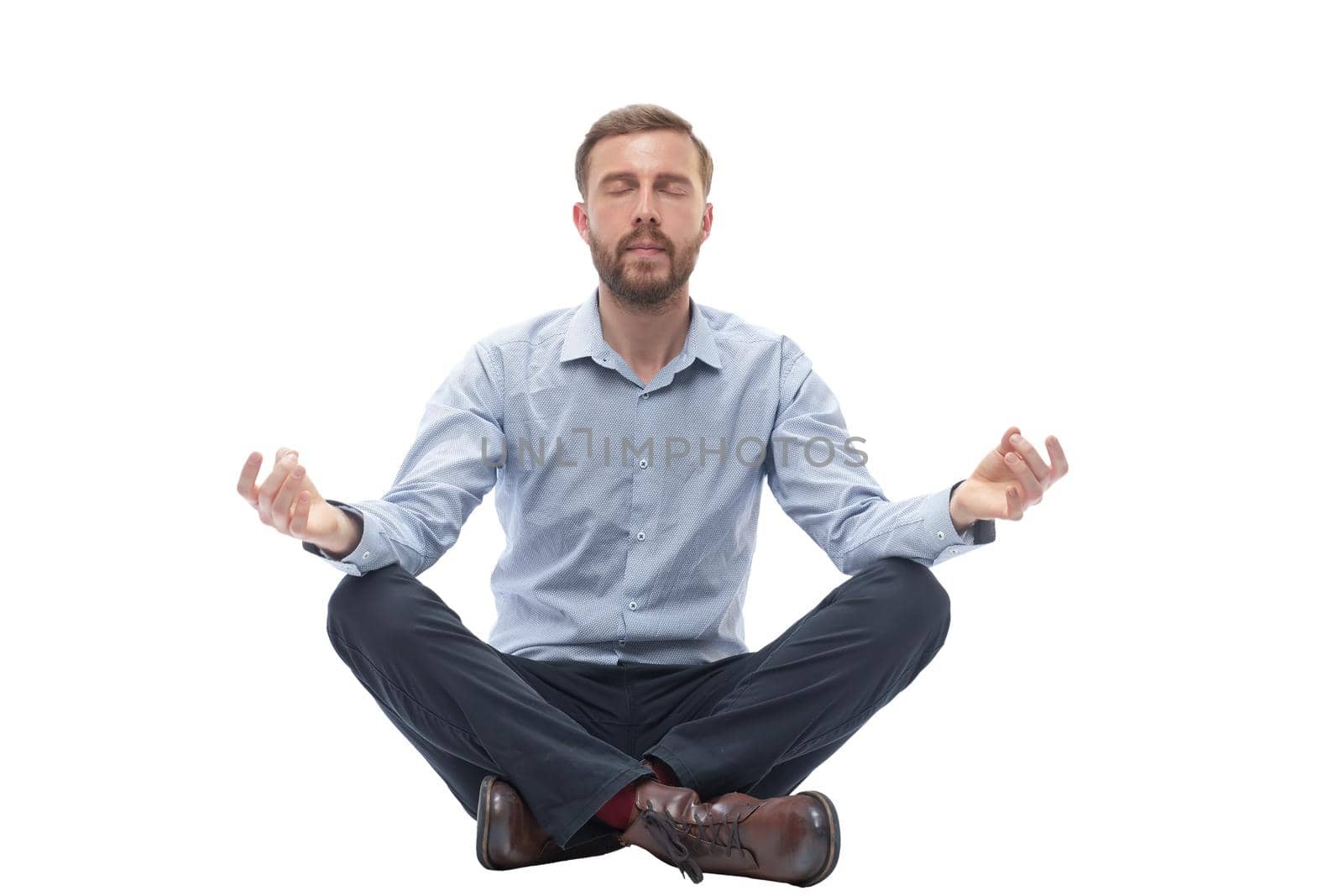 young businessman meditates sitting on the floor . isolated on white background