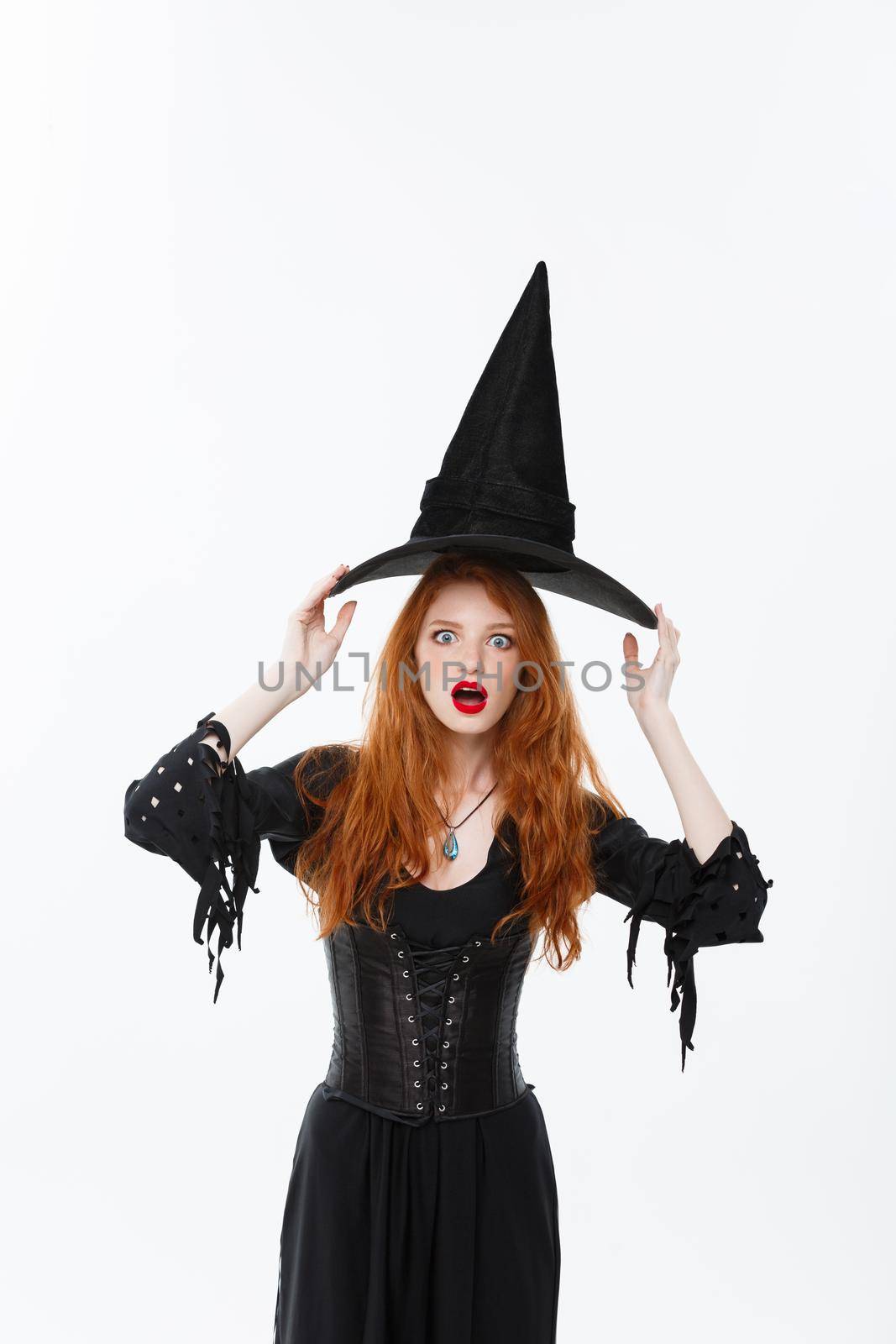 Halloween witch concept - Happy Halloween Sexy ginger hair Witch with magic hat flying over her head. Isolated on white background