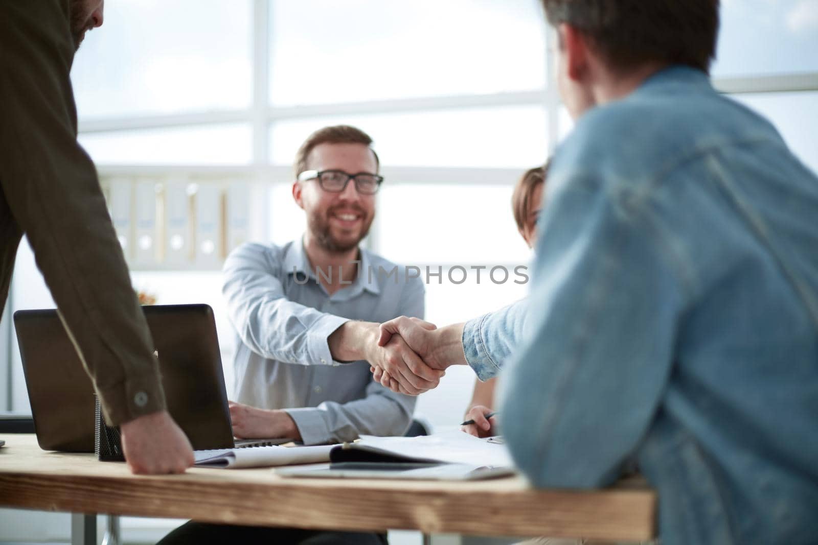 business man shaking hands with his colleague by asdf