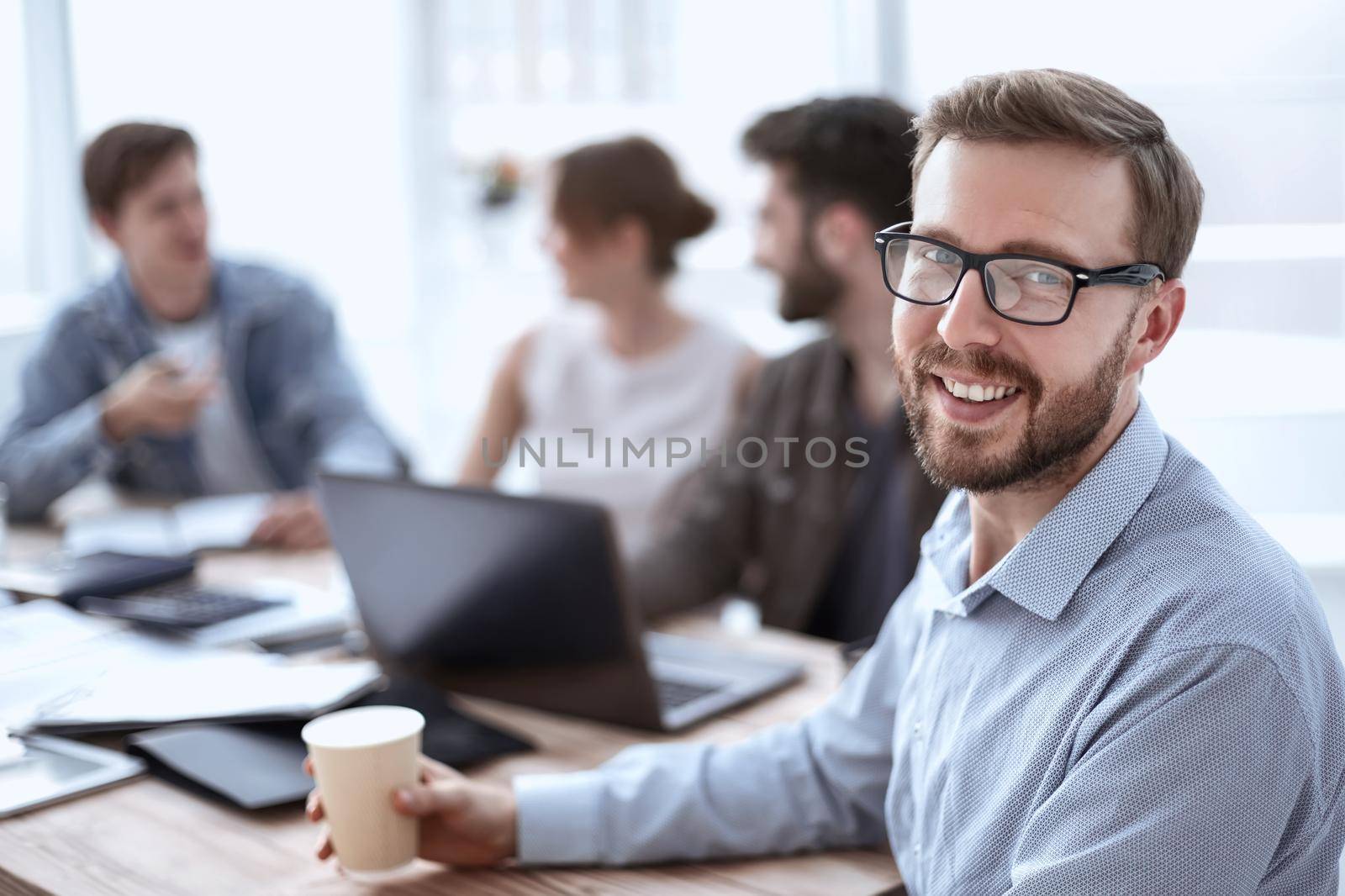 business man with a Cup of coffee sitting at a table in the office. photo with space for text