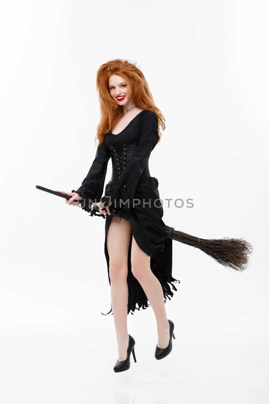 Halloween Witch Concept - Full-length Happy elegant witch with broomstick for celebrating halloween party over white background. by Benzoix