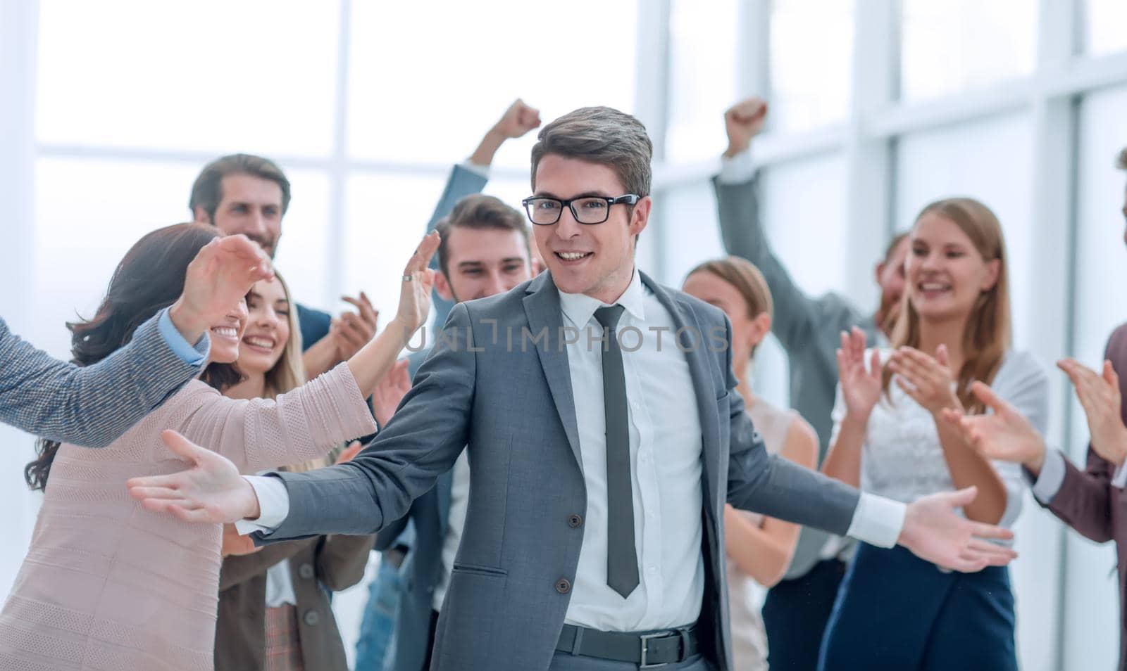happy young businessman standing in front of his business team. success concept