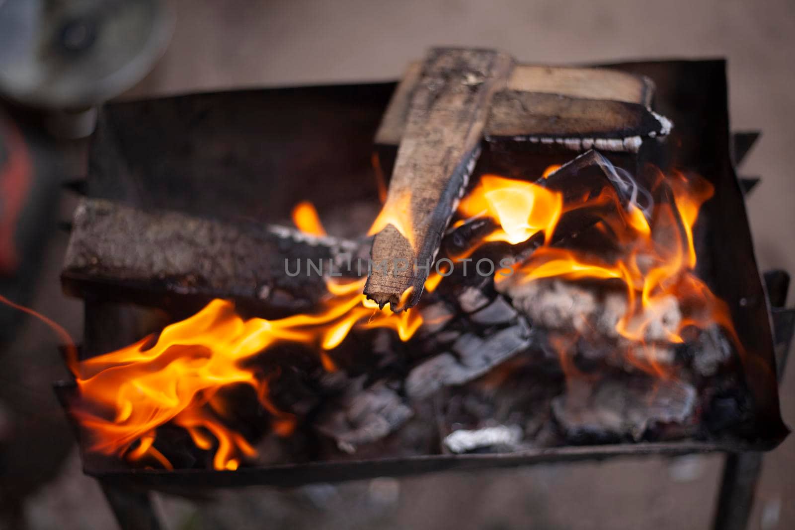 Firewood is burning. Burning dry branches. Creating coal. Picnic details. Unsafe flames.