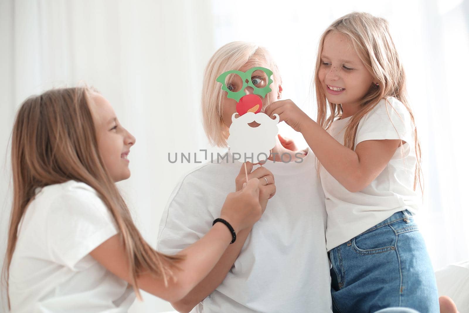 close up. two daughters play with mom sitting on the couch. the concept of family happiness