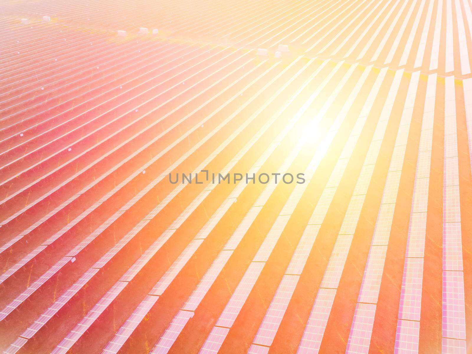 Aerial top view of a solar panels power plant. Photovoltaic solar panels at sunrise and sunset in countryside from above. Modern technology, climate care, earth saving, renewable energy concept