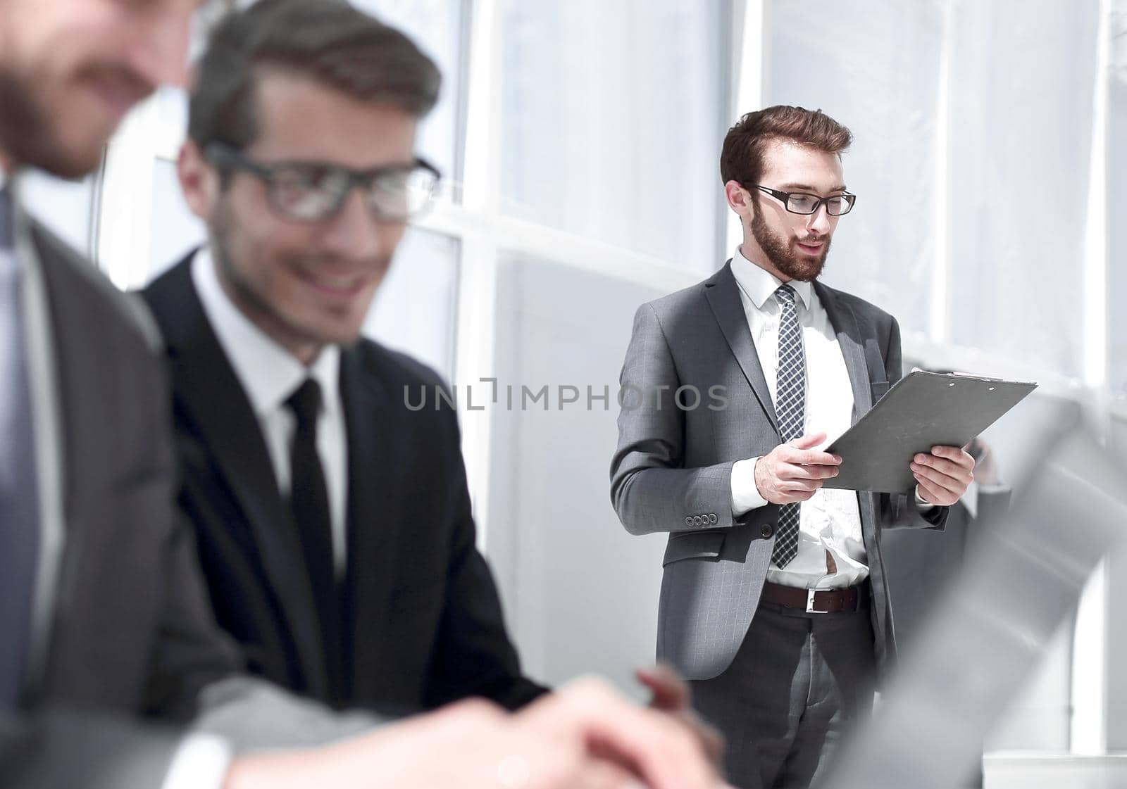 businessman with clipboard standing in a modern office.office weekdays