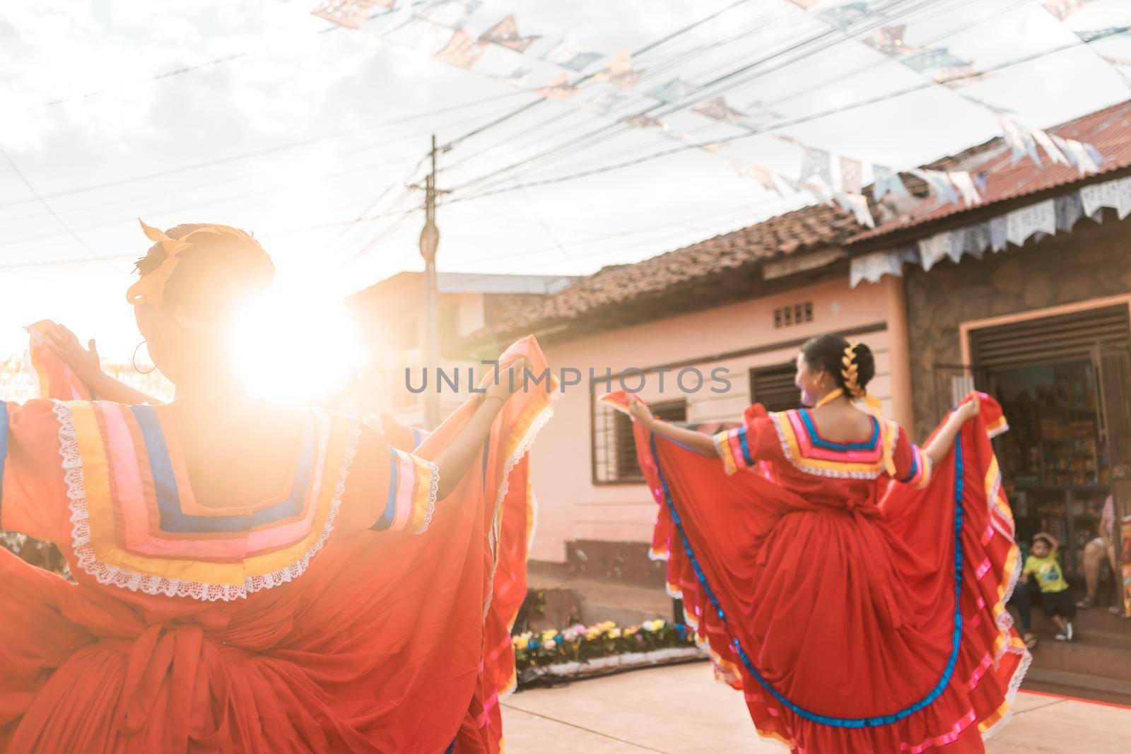 Traditional Nicaraguan dancers with typical tajes dancing on an outdoor stage during sunset