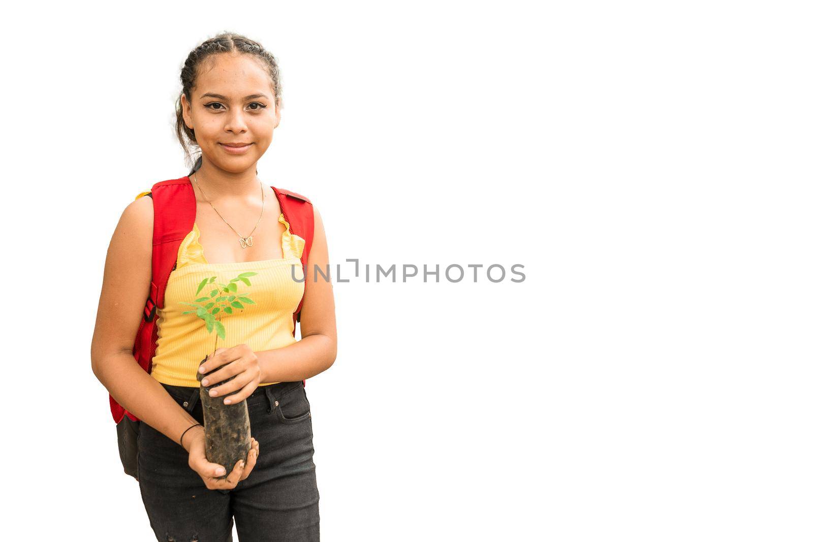 Portrait of a Latin girl holding a plant in a plastic bag watching the camera on a white background