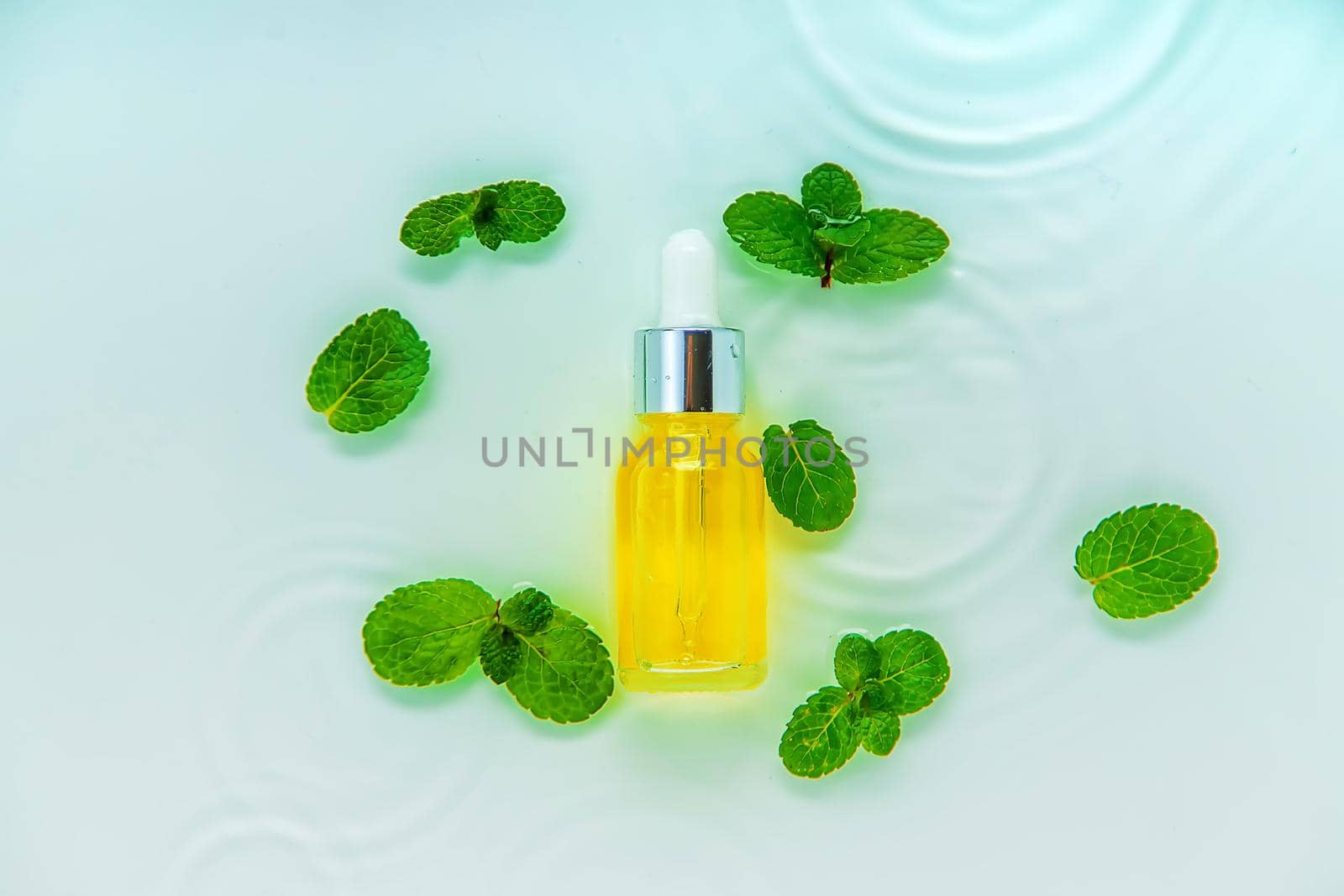 Cosmetics in a bottle in water, skin hydration concept. Selective focus. Nature.