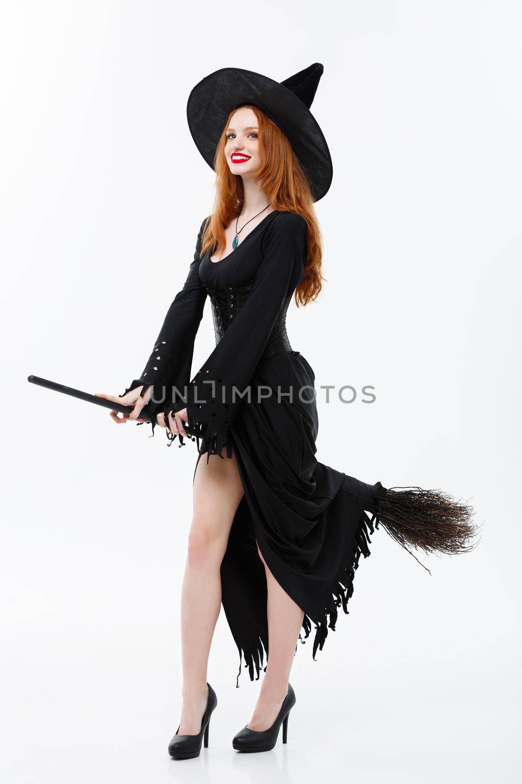 Halloween Witch Concept - Full-length Happy elegant witch with broomstick for celebrating halloween party over white background