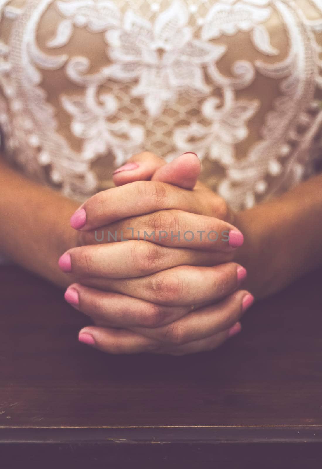 hands of a bride who prays during the wedding ceremony