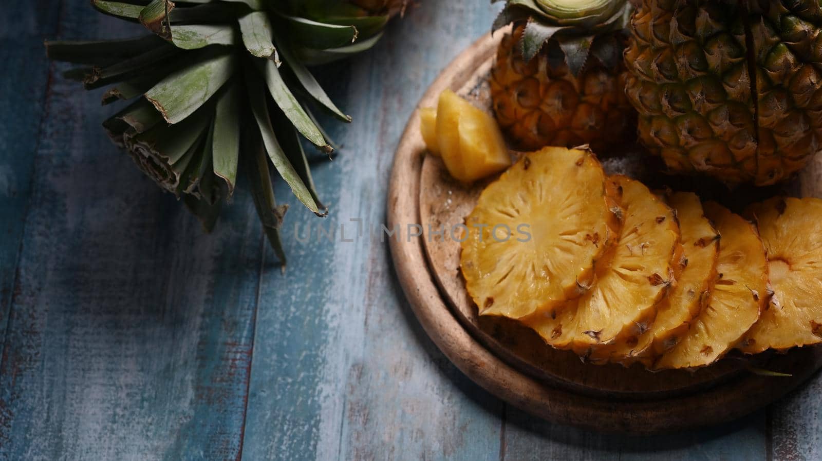 Whole and sliced tropical pineapple on wooden table. Top view, tropical fruits, summer concept.