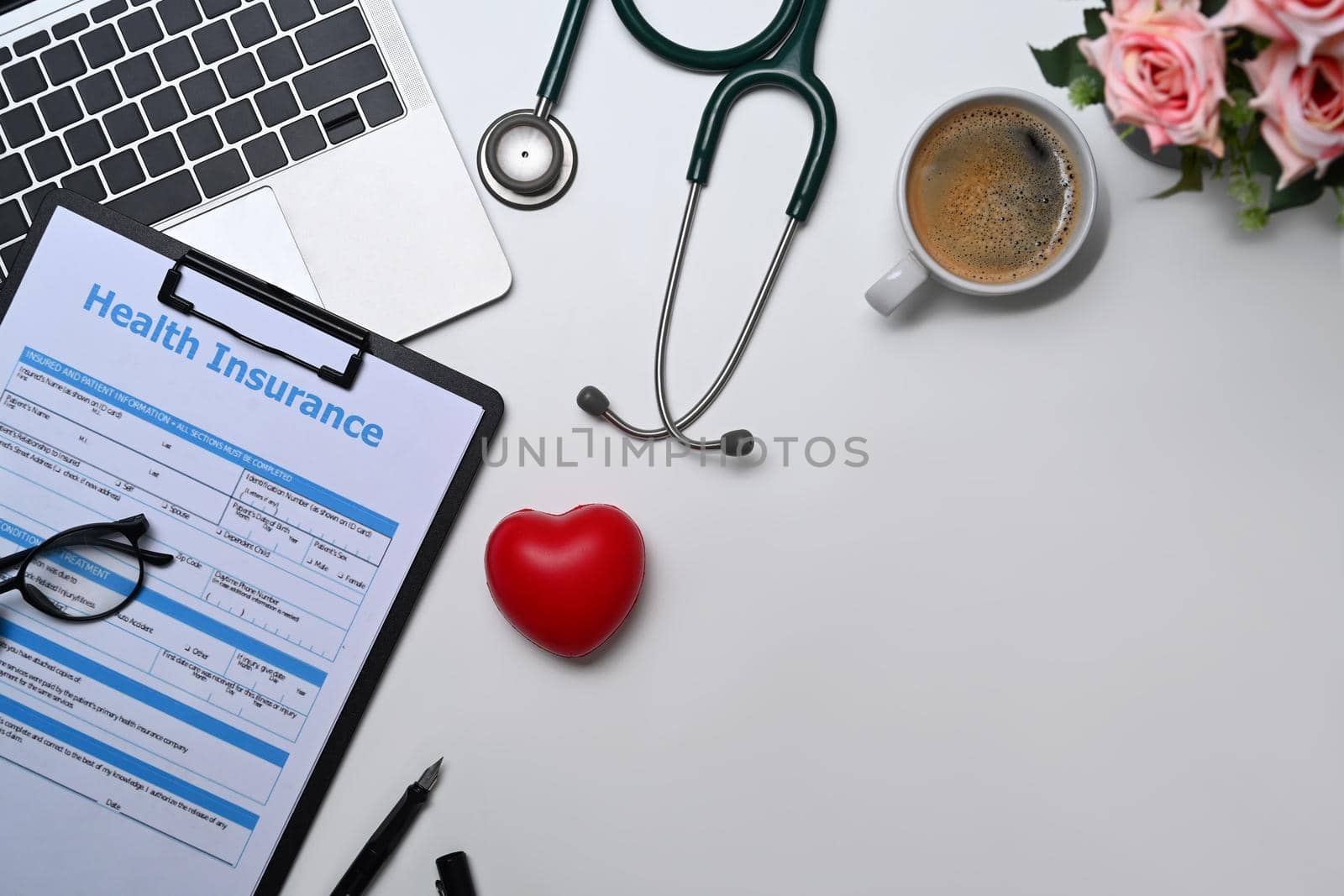 Top view laptop, stethoscope, medical report and heart on white table. Cardiology, healthcare and medical concept.