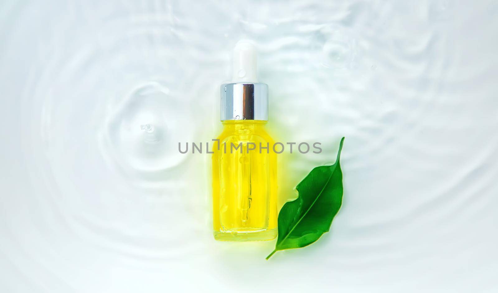 Cosmetics in a bottle in water, skin hydration concept. Selective focus. Nature.