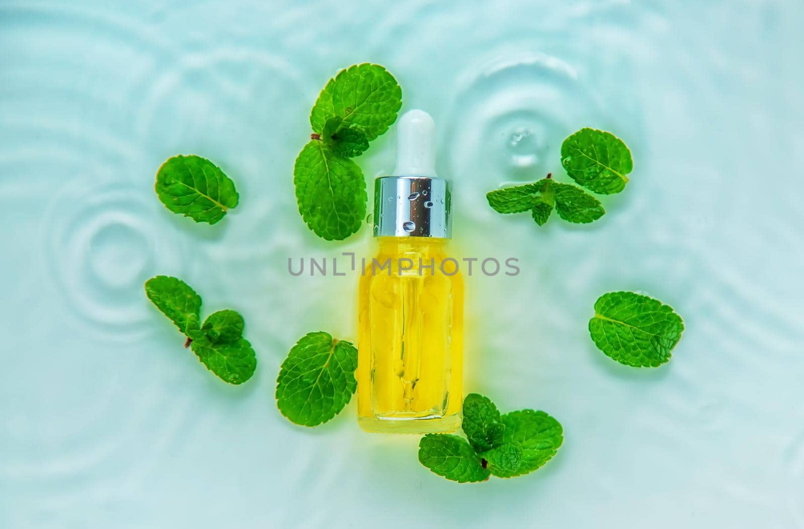 Cosmetics in a bottle in water, skin hydration concept. Selective focus. Nature.
