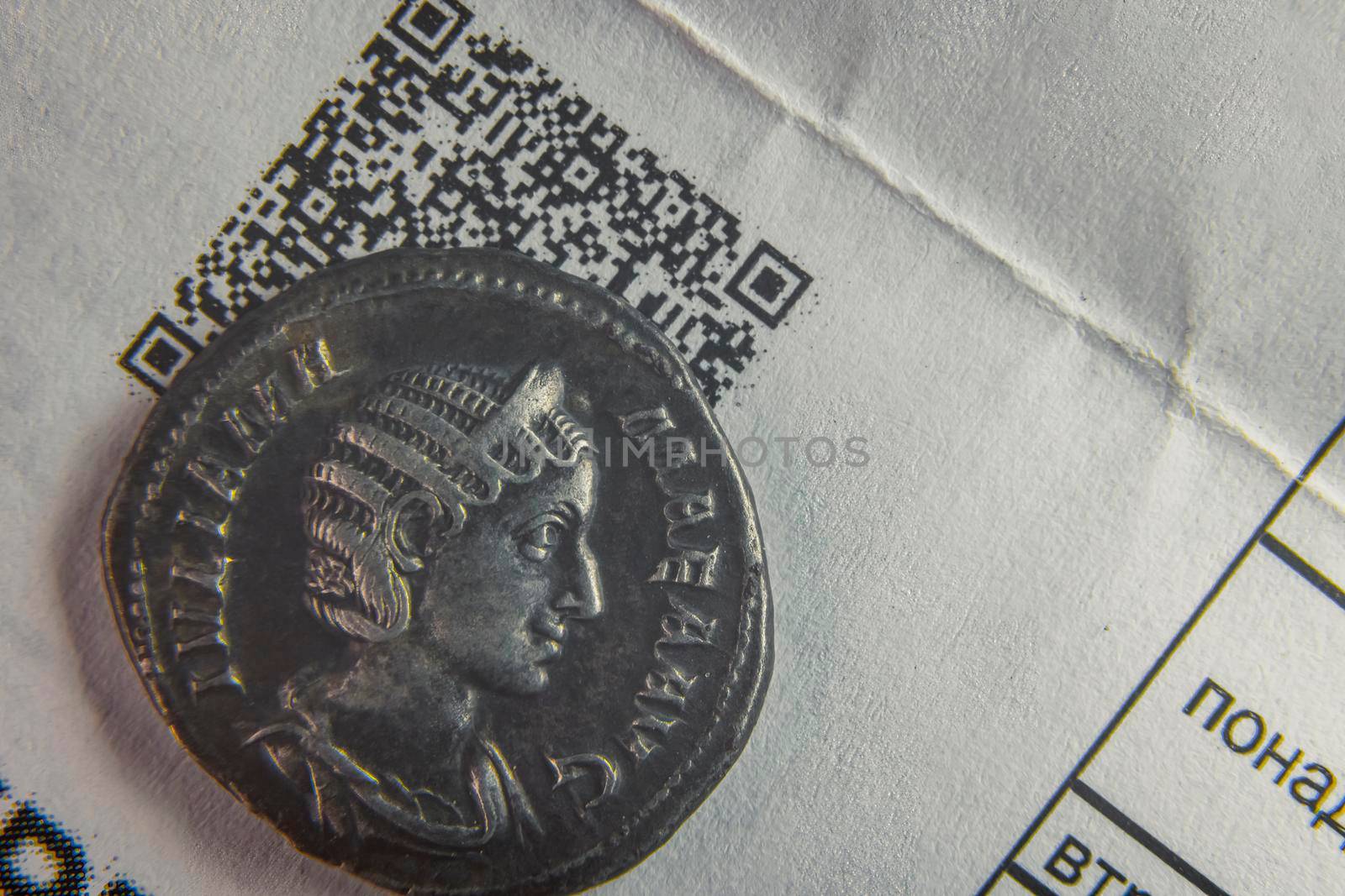 old coin on a sheet of paper with a cuar code close up