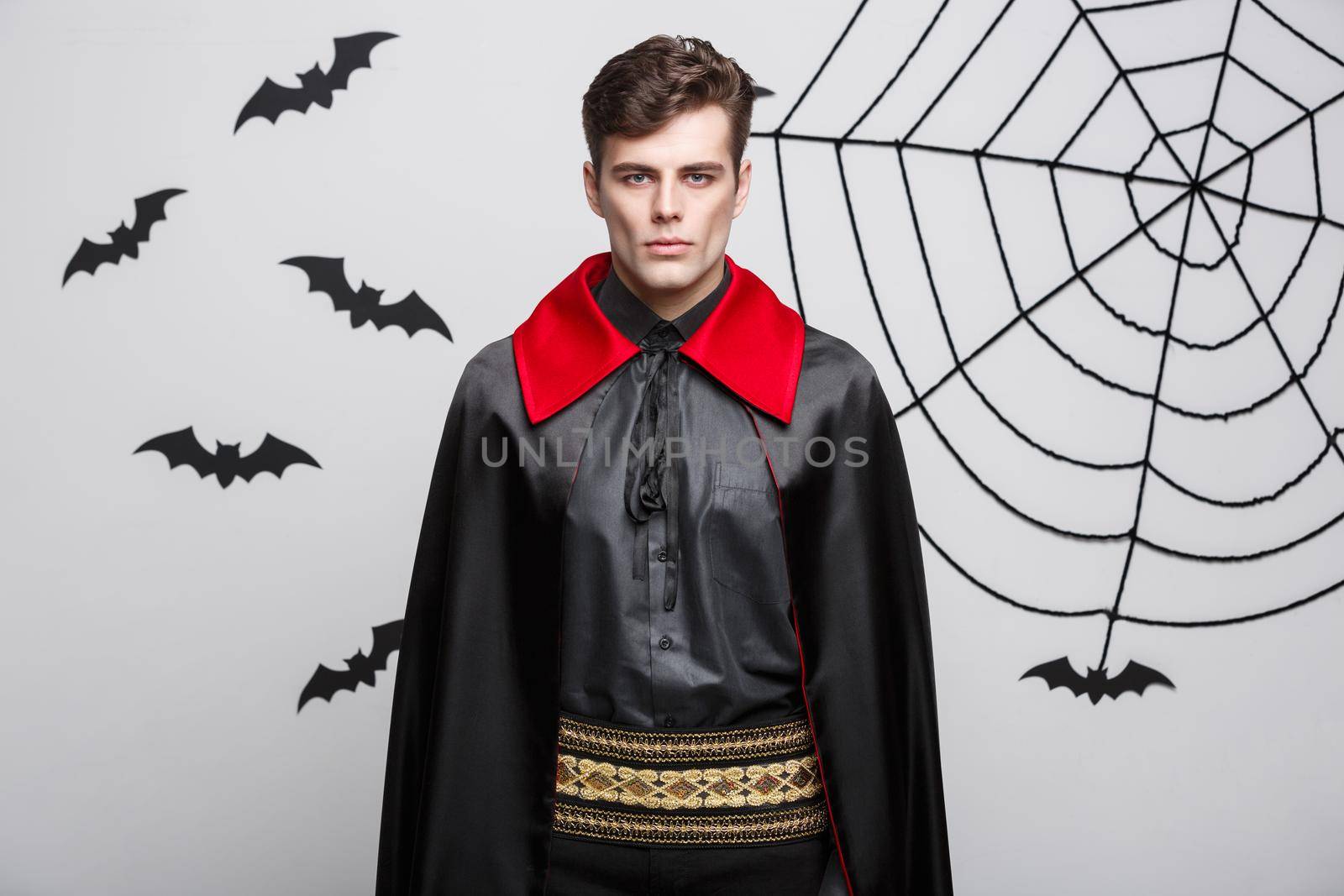 Vampire Halloween Concept - Portrait of handsome caucasian Vampire in black and red halloween costume