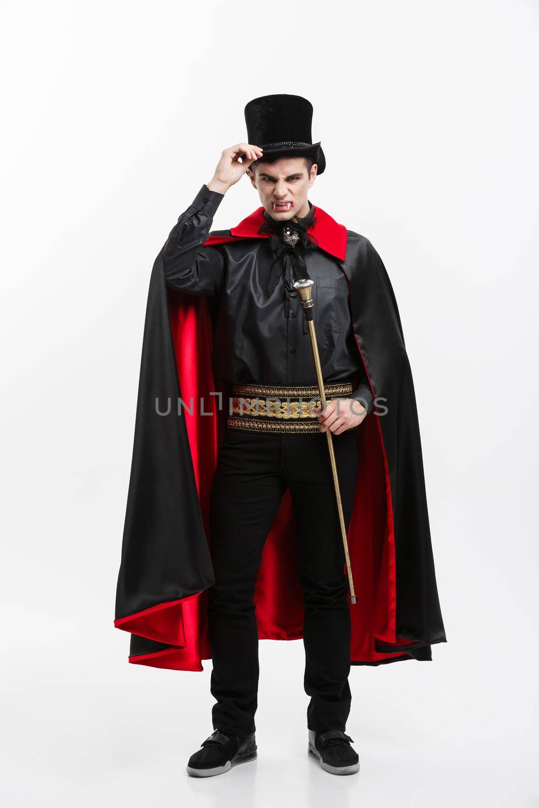 Vampire Halloween Concept - Full length Portrait of handsome caucasian Vampire in black and red halloween costume