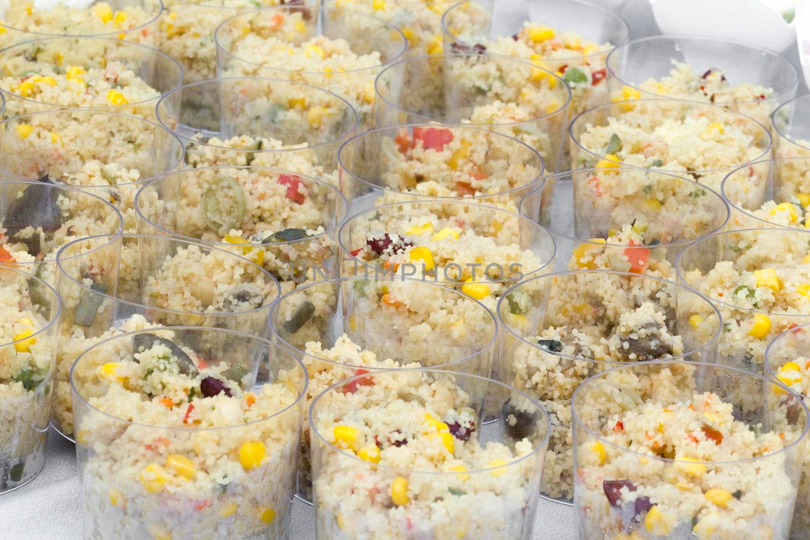 Vegetables couscous served in plastic cups.