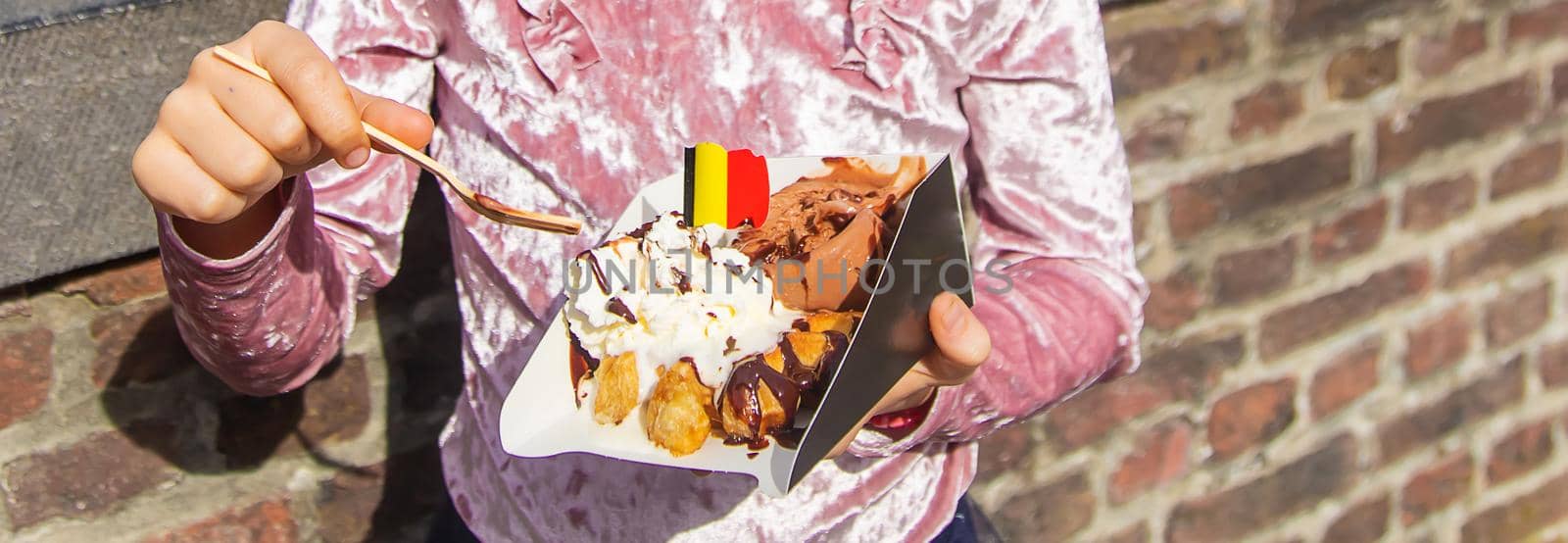 Belgian waffles are eaten by children on the street. Selective focus. Food.