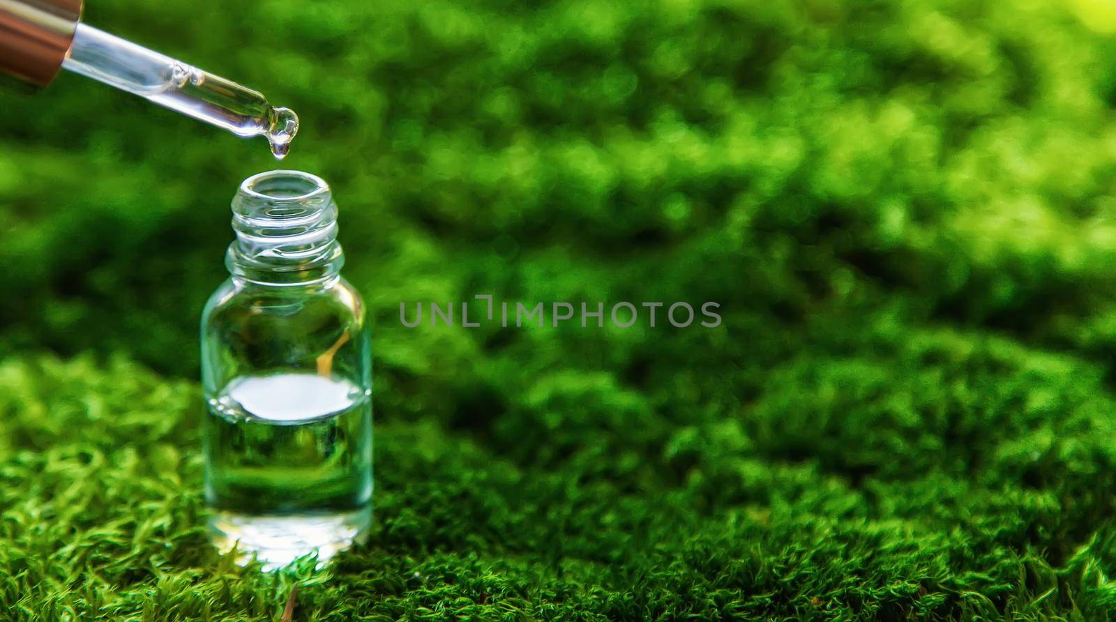 Cosmetics in a bottle and essential oils on moss. Natural spa. Selective focus. by yanadjana