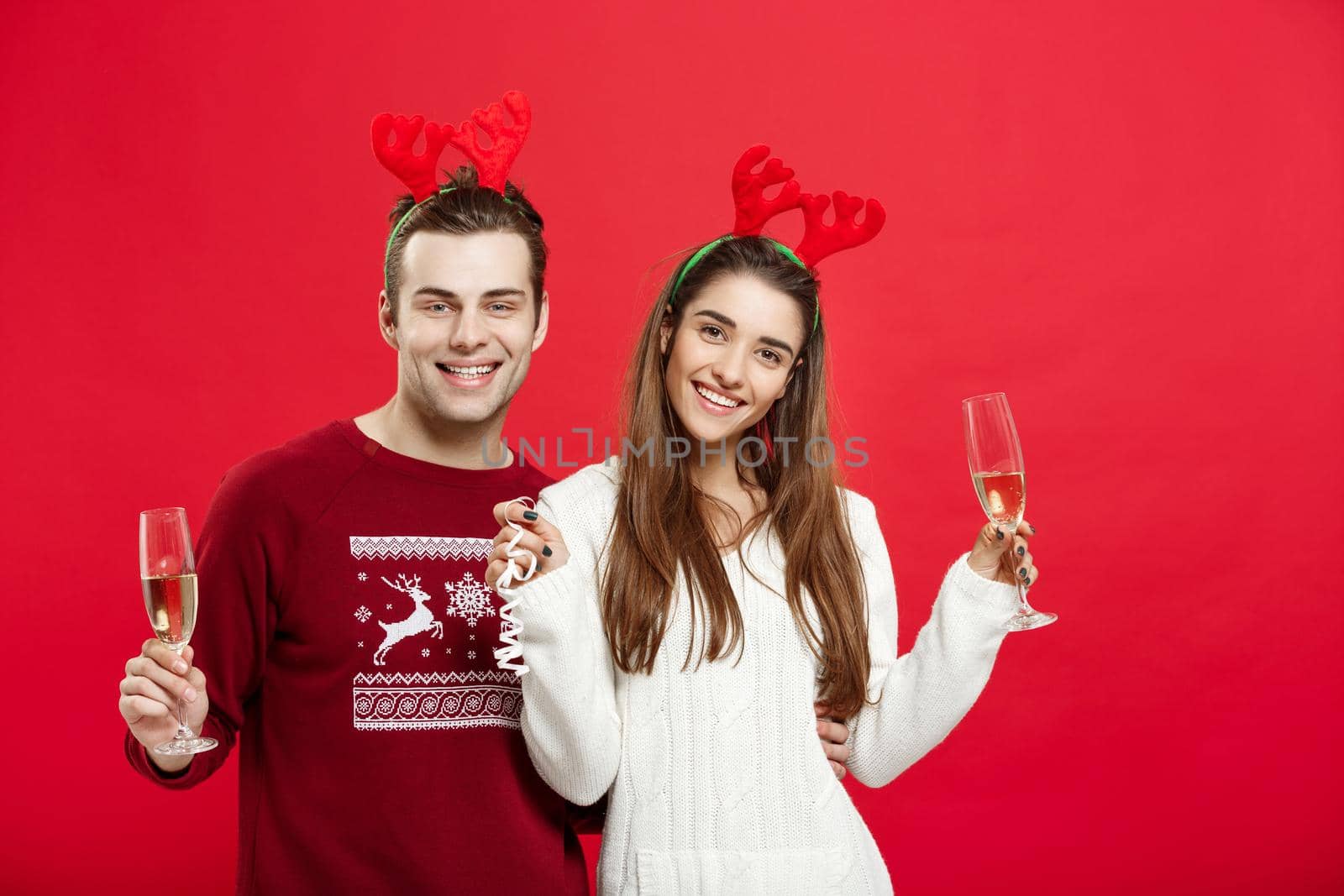 Christmas concept - Happy young couple in sweaters celebrating christmas with Champagne.