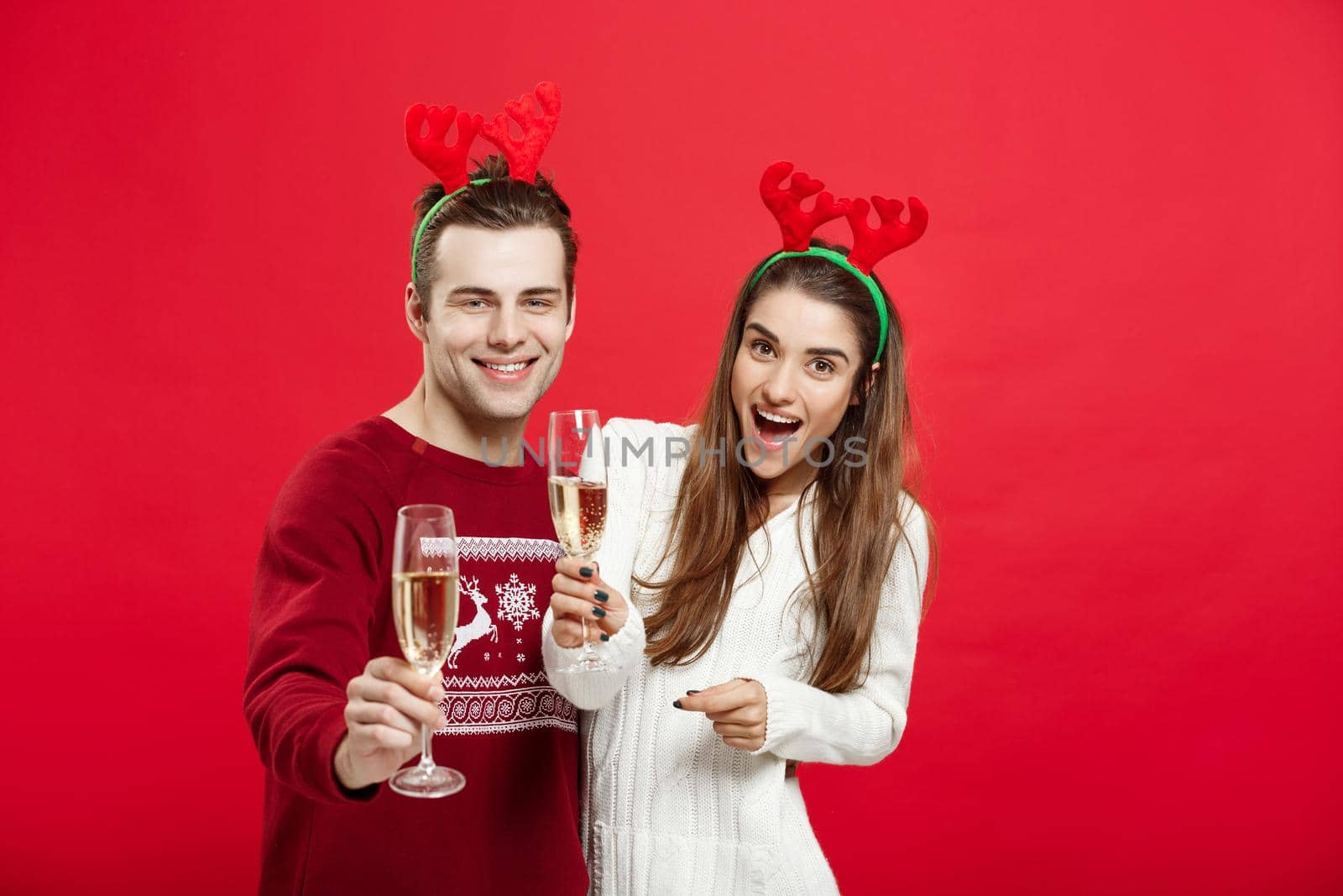 Christmas concept - Happy young couple in sweaters celebrating christmas with Champagne by Benzoix