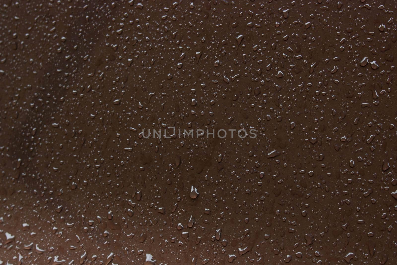 water drops on a brown metal surface, top view, for background. rain drips on the surface.