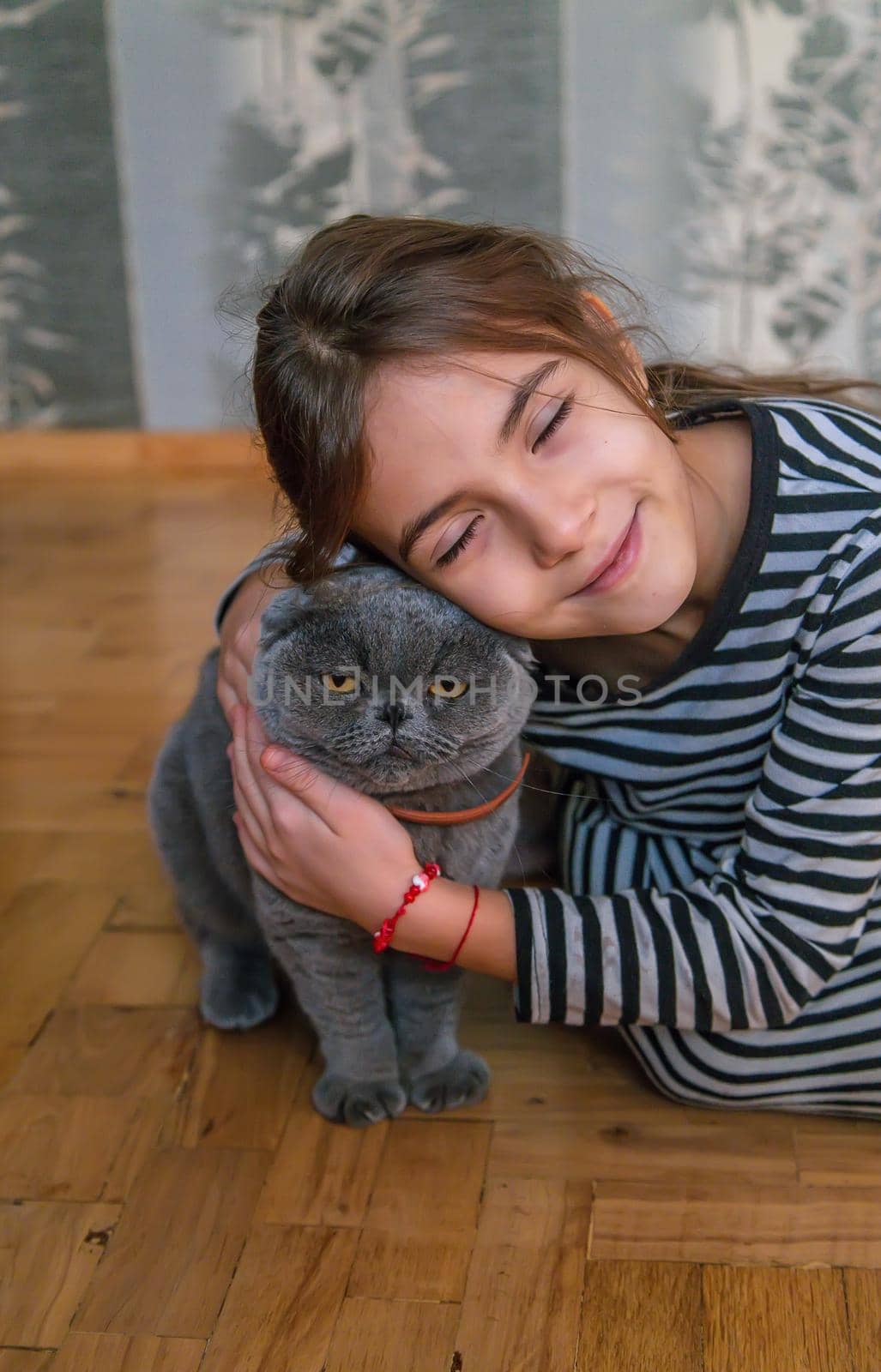 Child girl at home with a cat. Selective focus. Kid.