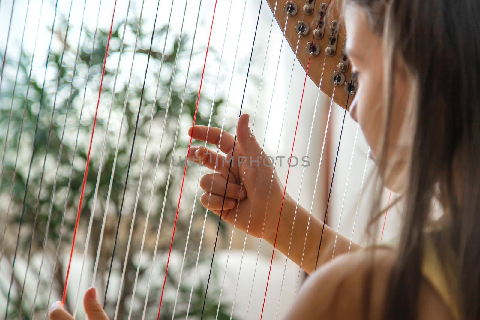 The child plays the harp. Selective focus. Kid.