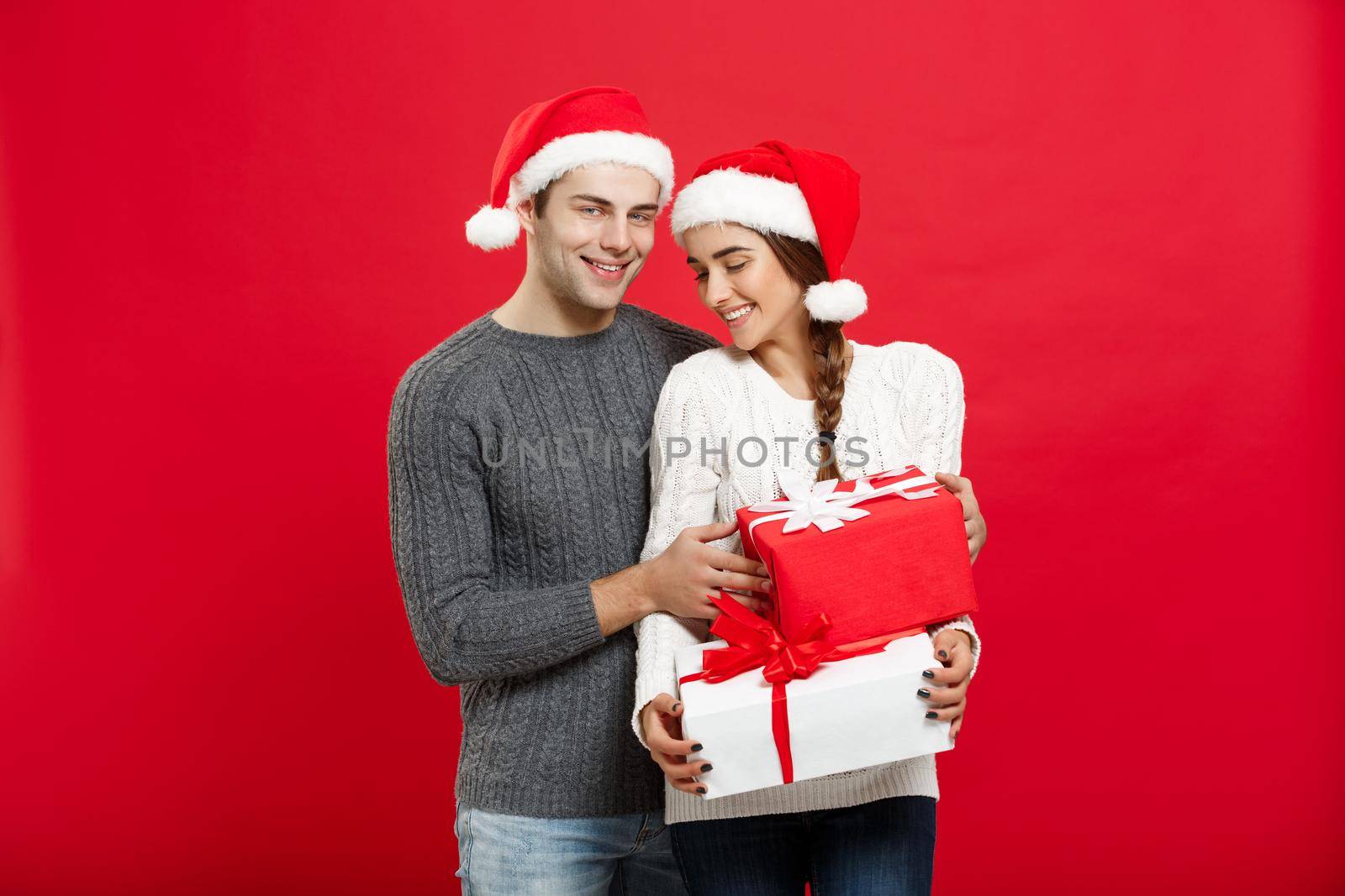 Christmas Concept - handsome young boyfriend in Christmas sweater surprise his girlfriend with gifts by Benzoix
